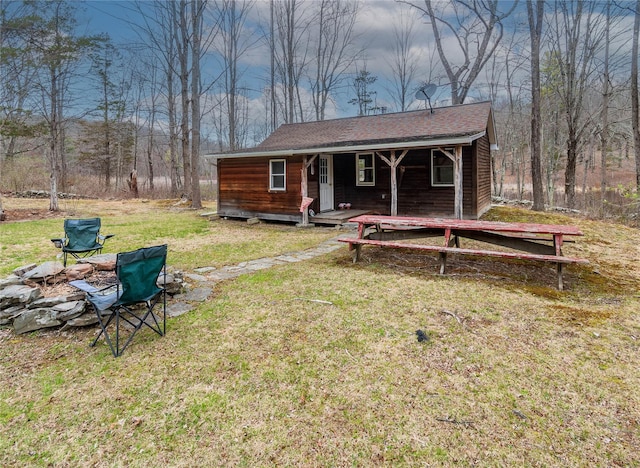 rear view of house with a yard and a porch