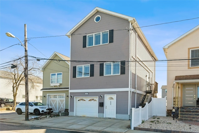 243 Sportsmans Ave, Freeport, NY 11520 - view of front of house with concrete driveway, fence, and a garage
