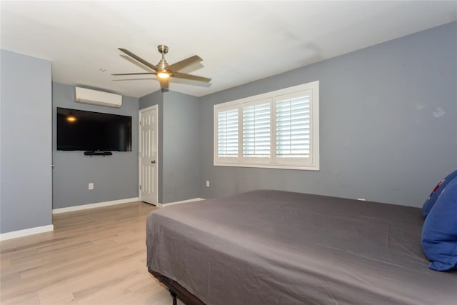 243 Sportsmans Ave, Freeport, NY 11520 - bedroom with ceiling fan, baseboards, light wood-style floors, and a wall unit AC