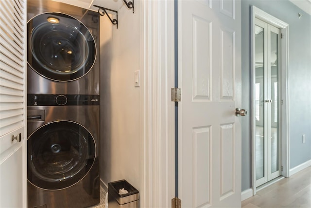 243 Sportsmans Ave, Freeport, NY 11520 - washroom with stacked washer and dryer, baseboards, and laundry area