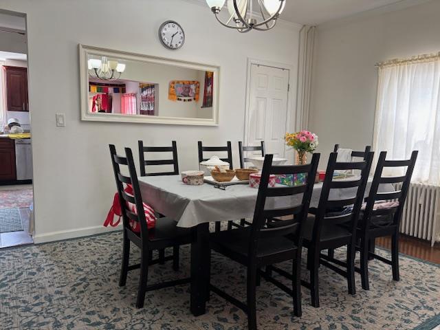 dining space featuring radiator heating unit, baseboards, and an inviting chandelier