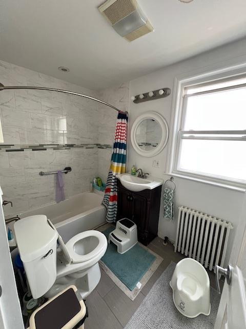 full bath with radiator, visible vents, toilet, vanity, and shower / tub combo with curtain