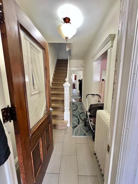 hallway with stairway and light tile patterned floors
