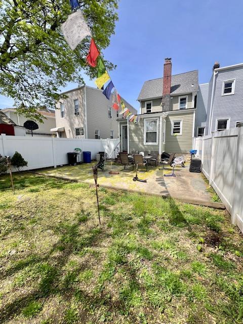 view of yard featuring entry steps, a fenced backyard, and a patio