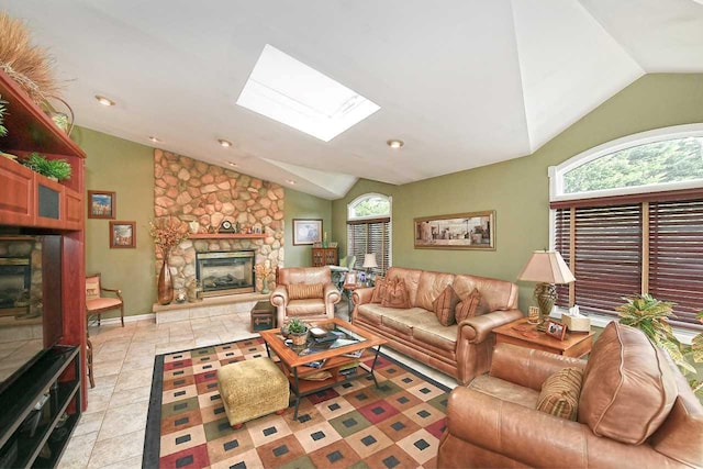 living room featuring a stone fireplace and lofted ceiling with skylight