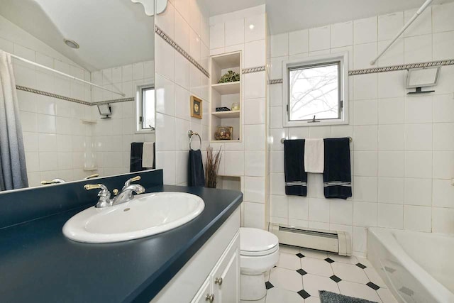 bathroom with tile walls, baseboard heating, and a healthy amount of sunlight