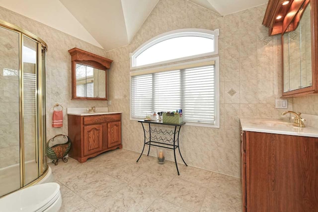 bathroom with vaulted ceiling, vanity, a shower with door, toilet, and tile patterned flooring