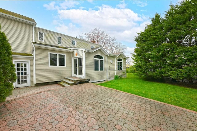 rear view of property featuring a lawn and a patio