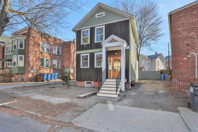 view of front of house with fence, board and batten siding, and entry steps