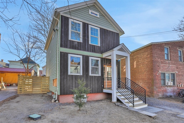 traditional-style home with fence and board and batten siding
