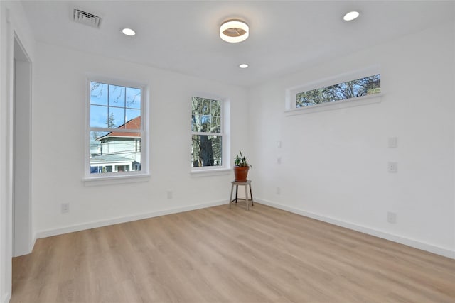spare room featuring light wood-style flooring, visible vents, a wealth of natural light, and recessed lighting