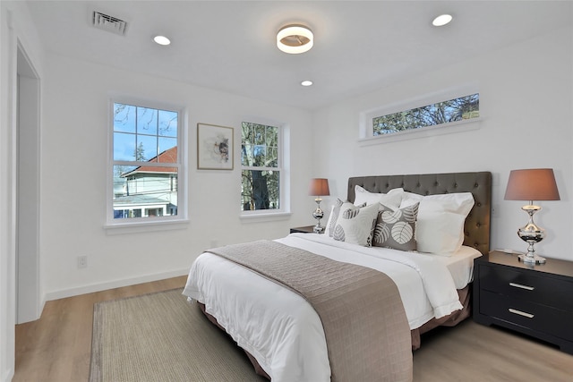 bedroom with recessed lighting, light wood-style flooring, visible vents, and multiple windows