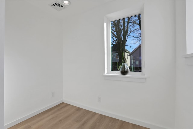 empty room featuring recessed lighting, light wood-style flooring, visible vents, and baseboards