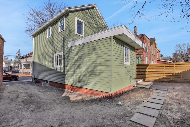 view of side of home featuring fence