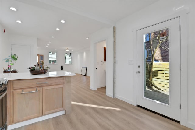 kitchen with light wood finished floors, light countertops, open floor plan, recessed lighting, and light brown cabinets