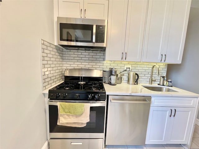 61-20 Grand Central Pkwy Unit A1503, Forest Hills, NY 11375 - kitchen featuring backsplash, appliances with stainless steel finishes, white cabinetry, and a sink