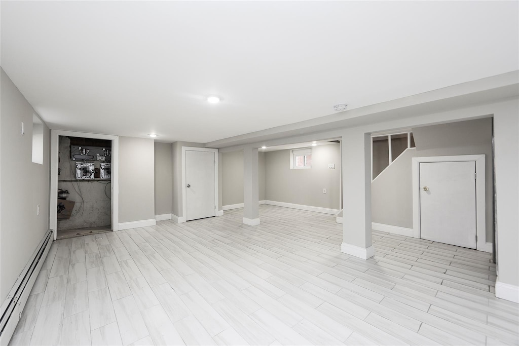 24027 Newhall Ave, Rosedale, NY 11422 - finished basement featuring baseboard heating, baseboards, and light wood finished floors