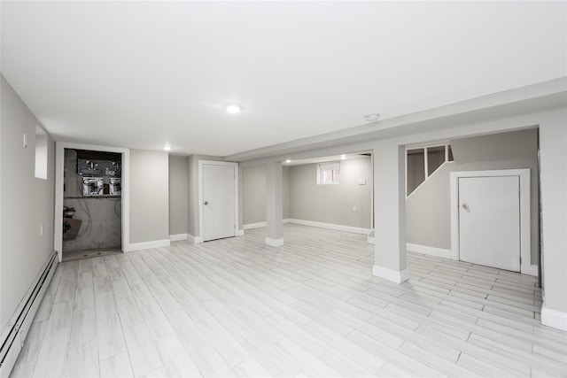 24027 Newhall Ave, Rosedale, NY 11422 - finished basement featuring baseboard heating, baseboards, and light wood finished floors