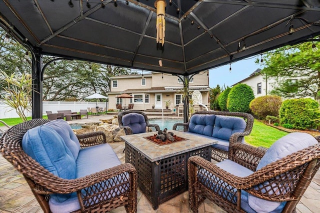 view of patio with an outdoor living space with a fire pit and fence