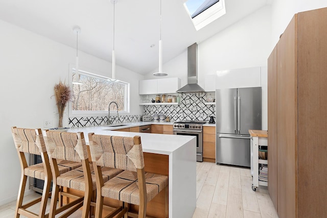 211 Red Dirt Rd, East Hampton, NY 11937 - kitchen featuring wall chimney range hood, a sink, high end appliances, modern cabinets, and a peninsula