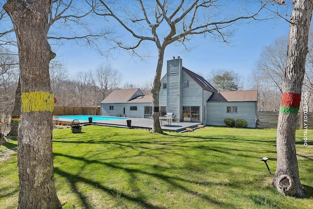 211 Red Dirt Rd, East Hampton, NY 11937 - back of house featuring a lawn, fence, a chimney, and a fenced in pool