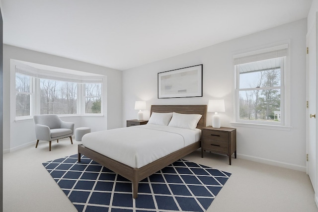 bedroom with baseboards, carpet, and multiple windows