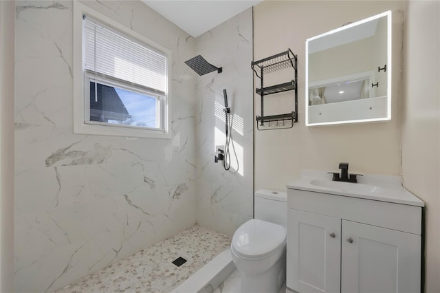 bathroom with toilet, a marble finish shower, and vanity