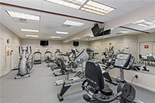 gym with baseboards, a ceiling fan, and a drop ceiling