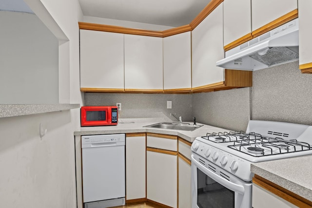 kitchen with under cabinet range hood, light countertops, a sink, and white appliances