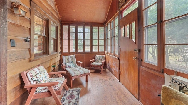 sunroom / solarium featuring wood-type flooring and wood walls