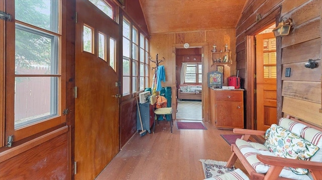 interior space with wooden walls, wood finished floors, and a wealth of natural light