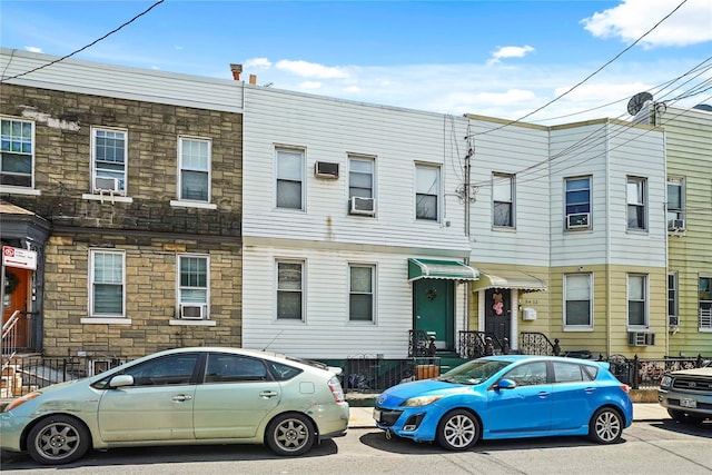 townhome / multi-family property featuring cooling unit and stone siding