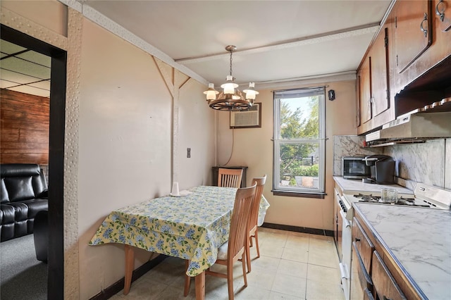 dining area with baseboards, an AC wall unit, and a chandelier