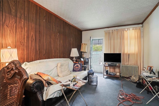carpeted living area with a textured ceiling, wood walls, ornamental molding, and radiator heating unit