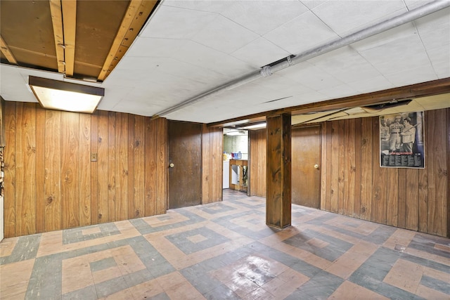 finished below grade area featuring tile patterned floors and wooden walls