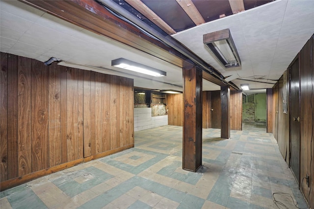 basement with wooden walls and tile patterned floors