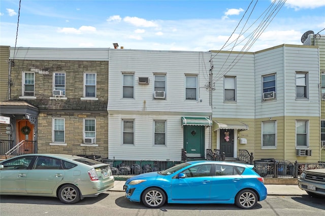 townhome / multi-family property featuring stone siding and cooling unit