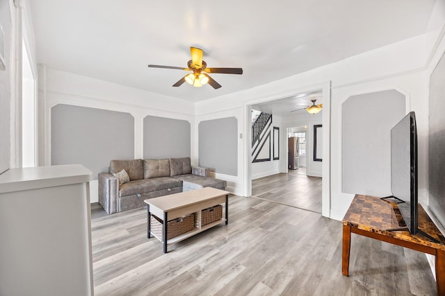 69-06 79th St, Middle Village, NY 11379 - living area featuring ceiling fan, light wood-style flooring, and stairs