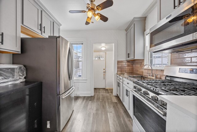69-06 79th St, Middle Village, NY 11379 - kitchen with stainless steel appliances, a sink, plenty of natural light, and light wood-style floors