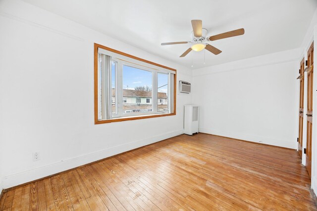 69-06 79th St, Middle Village, NY 11379 - unfurnished room with a wall mounted AC, light wood-style floors, baseboards, ceiling fan, and radiator