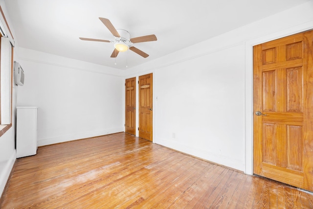 69-06 79th St, Middle Village, NY 11379 - spare room featuring ceiling fan, light wood finished floors, an AC wall unit, and baseboards