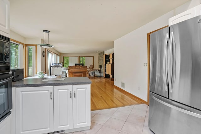 48 Sabbath Day Hill Rd, South Salem, NY 10590 - kitchen with freestanding refrigerator, dark countertops, white cabinets, a peninsula, and light tile patterned floors