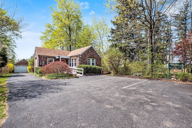 single story home with uncovered parking and stone siding