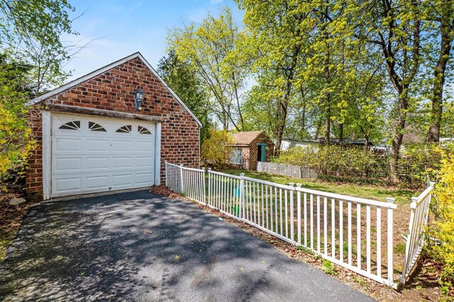 garage with fence and aphalt driveway