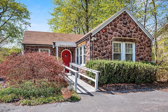 ranch-style house featuring stone siding
