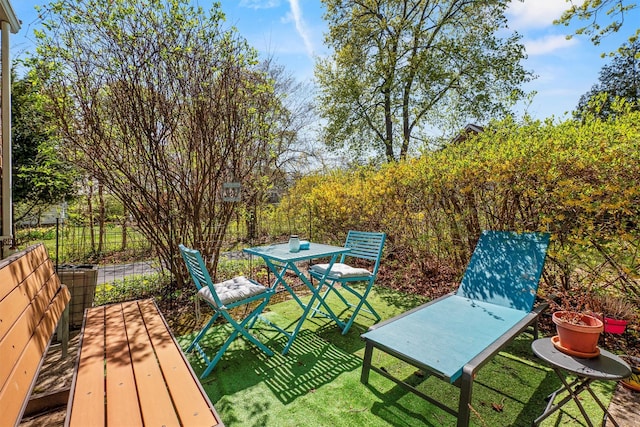 wooden terrace with a lawn, fence, and outdoor dining space