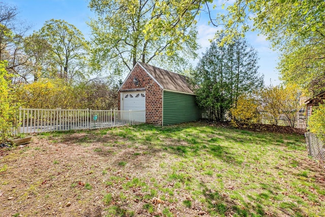 view of yard with fence, an outbuilding, and a garage