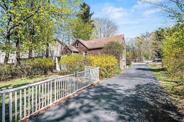 view of home's exterior with brick siding and fence