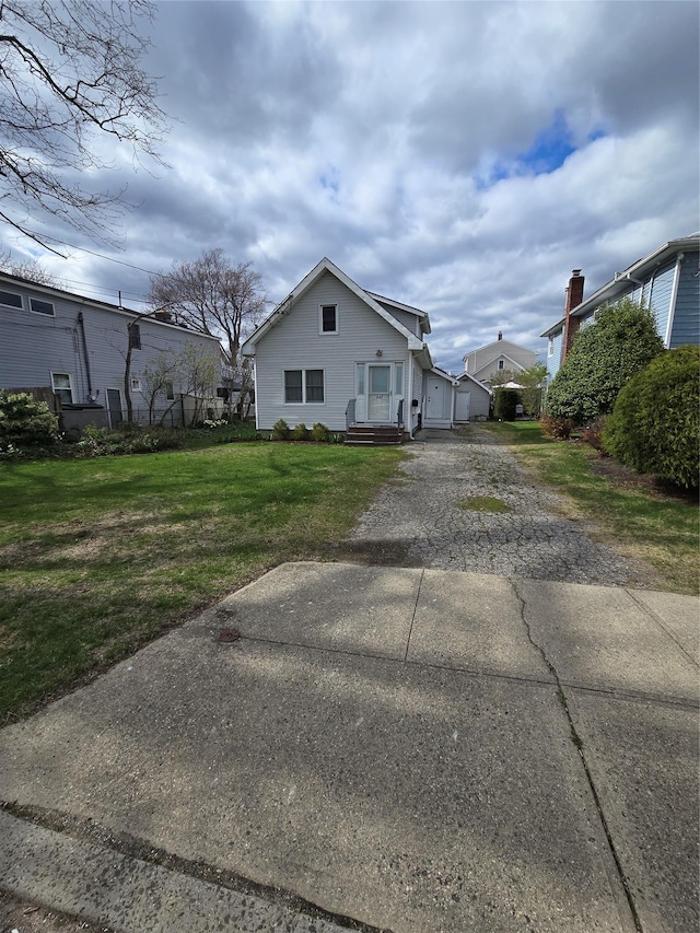 view of front of house with gravel driveway and a front lawn