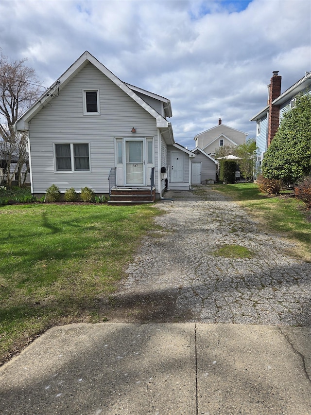 bungalow-style home with driveway and a front yard